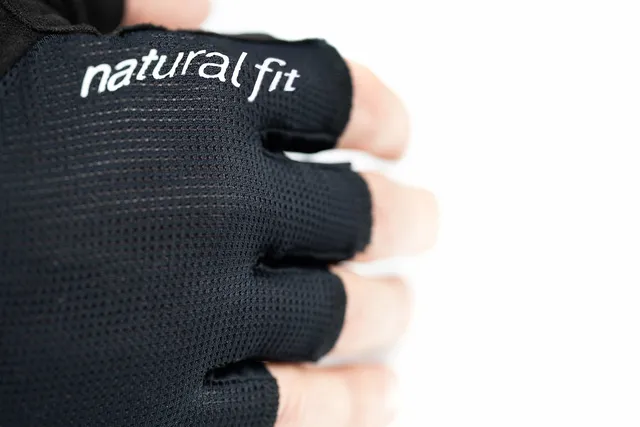 Nahaufnahme einer Hand, die den schwarzen fingerlosen Handschuh CUBE Handschuhe kurzfinger X NF mit "natural fit" in weißer Schrift auf dem Handrücken trägt, vor weißem Hintergrund., Ansicht 4