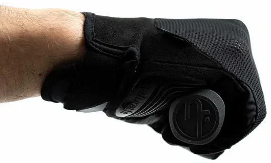 Eine Nahaufnahme des Arms und der Hand einer Person, die den schwarzen Handschuh CUBE Handschuhe langfinger X NF trägt. Die Finger sind zu einer Faust gerollt und halten ein rundes schwarzes Objekt, das sich vor einem schlichten weißen Hintergrund befindet - eine Anlehnung an den charakteristischen Stil von Bike Lichtenfels., Ansicht 5