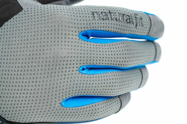Eine Nahaufnahme des grau-blauen CUBE Handschuhs langfinger X NF mit dem Aufdruck "natural" auf dem Handrücken, der das strukturierte Material und die detaillierten Nähte hervorhebt., Ansicht 4