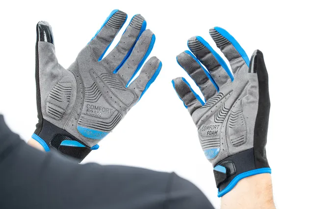 Eine Person mit grauen und blauen CUBE Handschuhen langfinger X NF mit Comfort Foam-Aufdruck auf den Handflächen, die Vorder- und Rückseite beider Hände vor einem weißen Hintergrund zeigen., Ansicht 6