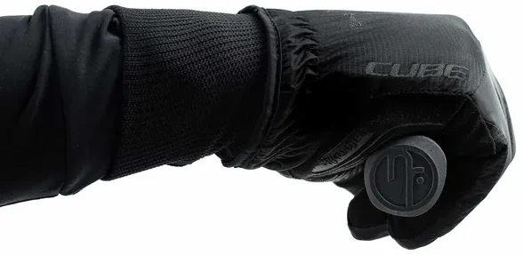 Eine Hand, die den schwarzen isolierten CUBE Handschuh Winter langfinger X NF trägt, greift ein schwarzes, kreisförmiges Objekt mit dem Logo von Mr. Bike Lichtenfels vor einem schlichten weißen Hintergrund., Ansicht 5
