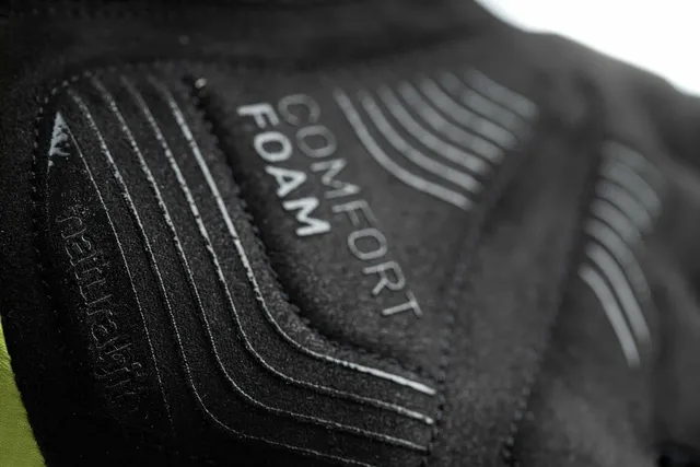 Nahaufnahme einer schwarzen Stoffoberfläche mit geprägten Linien und dem Schriftzug COMFORT FOAM in Weiß, die wahrscheinlich zu den CUBE Handschuhen Winter langfinger X NF gehören, was auf robuste und schützende Winterradhandschuhe hindeutet., Ansicht 4