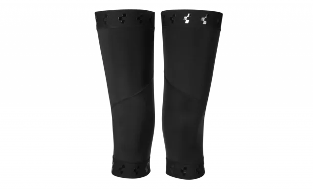 Die CUBE Knielinge RACE cold conditions sind schwarze Knieschutzhüllen mit elastischen Öffnungen, kleinen Aussparungen und einem dezenten, reflektierenden Logo in der Nähe der Oberseite auf weißem Hintergrund.