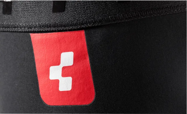 Die CUBE Knielinge RACE cold conditions sind schwarze Knieschutzhüllen mit elastischen Öffnungen, kleinen Aussparungen und einem dezenten, reflektierenden Logo in der Nähe der Oberseite auf weißem Hintergrund., Ansicht 3