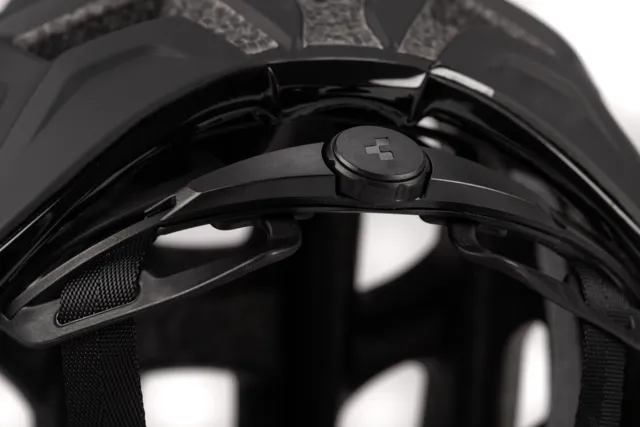 Nahaufnahme des CUBE Helm ROAD RACE, ein schwarzer Helm mit großen Belüftungsöffnungen und silbern glänzendem "CUBE"-Schriftzug auf einer matten Oberfläche. Die Polsterung und die Materialstruktur des Helms sind deutlich zu erkennen. Erhältlich bei Mr. Bike Lichtenfels., Ansicht 4