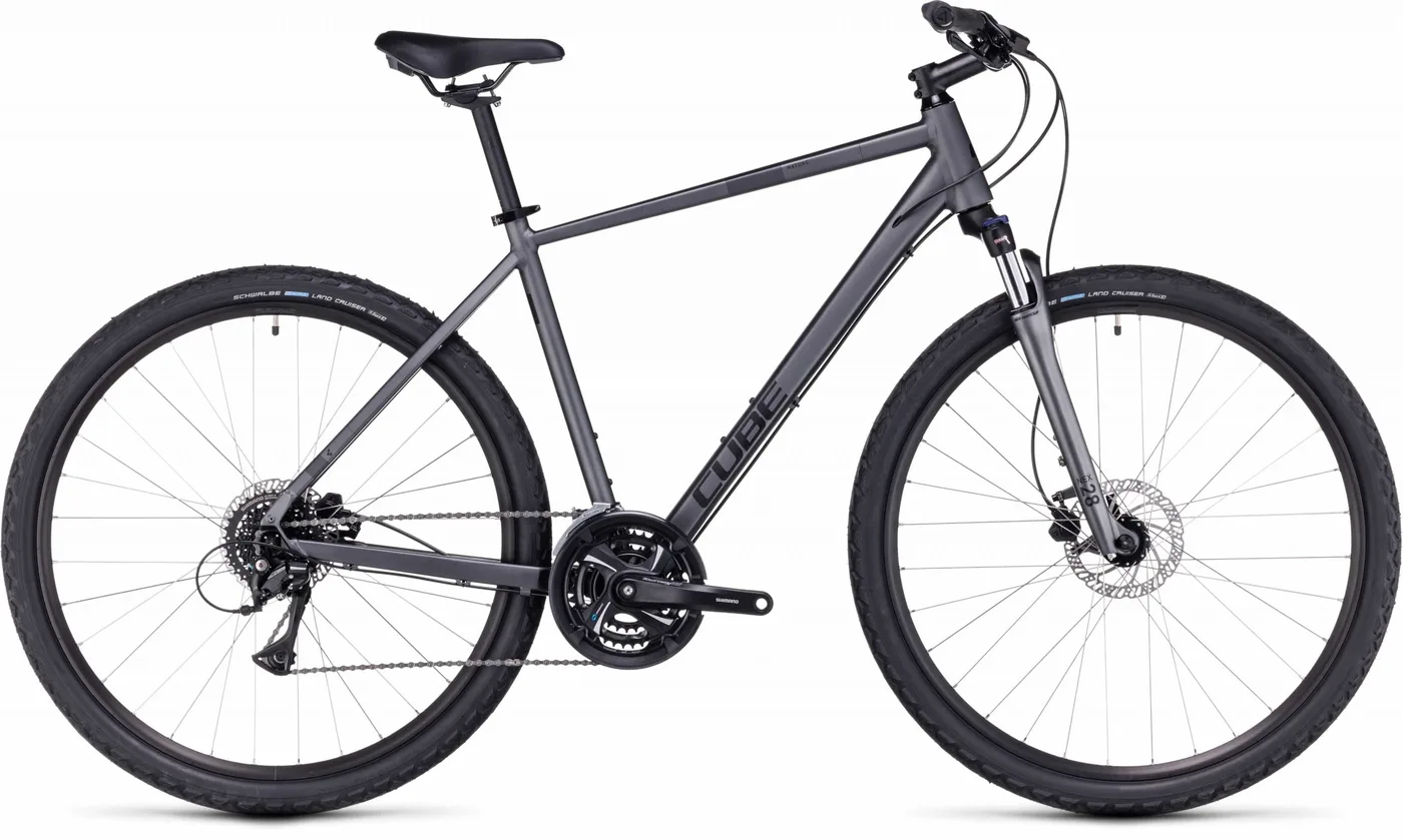 Ein CUBE Nature graphite'n'black Hybridbike mit mattschwarzem Finish, geradem Lenker, schlankem Rahmen, Federgabel, Scheibenbremsen und großen Reifen wird von der Seite vor einem weißen Hintergrund gezeigt.