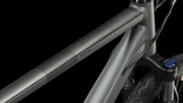 Ein CUBE Nature graphite'n'black Hybridbike mit mattschwarzem Finish, geradem Lenker, schlankem Rahmen, Federgabel, Scheibenbremsen und großen Reifen wird von der Seite vor einem weißen Hintergrund gezeigt., Ansicht 2