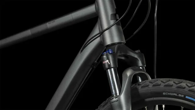 Ein CUBE Nature graphite'n'black Hybridbike mit mattschwarzem Finish, geradem Lenker, schlankem Rahmen, Federgabel, Scheibenbremsen und großen Reifen wird von der Seite vor einem weißen Hintergrund gezeigt., Ansicht 6