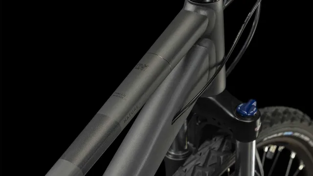 Ein CUBE Nature graphite'n'black Hybridbike mit mattschwarzem Finish, geradem Lenker, schlankem Rahmen, Federgabel, Scheibenbremsen und großen Reifen wird von der Seite vor einem weißen Hintergrund gezeigt., Ansicht 7