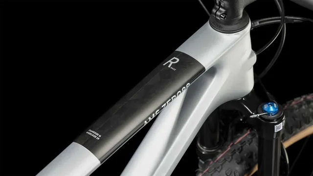 Das CUBE AMS ZERO99 C:68X Race 29 in silver'n'black, mit Vollfederung, schwarzem Sattel und hellbraunen Schwalbe-Reifen ist in der Seitenansicht vor weißem Hintergrund zu sehen., Ansicht 2