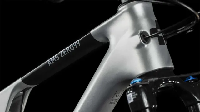 Das CUBE AMS ZERO99 C:68X Race 29 in silver'n'black, mit Vollfederung, schwarzem Sattel und hellbraunen Schwalbe-Reifen ist in der Seitenansicht vor weißem Hintergrund zu sehen., Ansicht 3