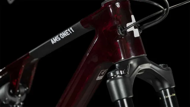 Das CUBE AMS ONE11 C:68X Pro 29 in liquidred'n'carbon ist ein vollgefedertes Mountainbike mit breiten Stollenreifen, Scheibenbremsen und einem abfallenden Oberrohr, hier in der Seitenansicht vor weißem Hintergrund., Ansicht 7