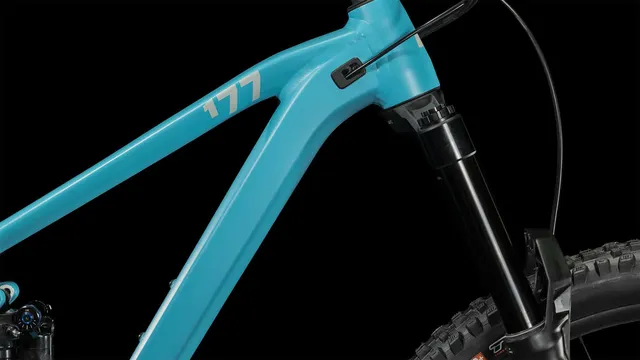 Ein CUBE Stereo ONE77 Race 29 Mountainbike in bondiblue'n'grey, mit Vollfederung, großen Stollenreifen, schwarzem Sattel und schwarzem Lenker, fotografiert von der Seite auf weißem Hintergrund., Ansicht 3