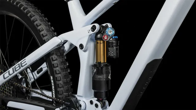 Das CUBE Stereo ONE77 C:68X SLT 29 in flashwhite'n'grey von Mr. Bike Lichtenfels ist mit schwarzen, goldenen und blauen Komponenten, dicken Maxxis-Reifen, Scheibenbremsen und einer Dropper-Sattelstütze ausgestattet - alles auf einem schlichten weißen Hintergrund., Ansicht 7
