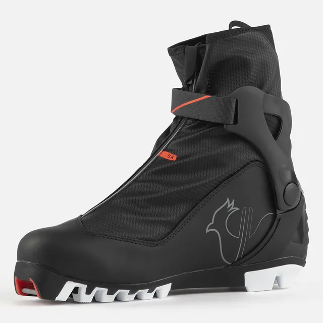 Der ROSSIGNOL X-6 SKATE ist ein schwarzer Langlaufschuh mit rotem Akzent, Knöchelstützriemen, Außenhülle mit Reißverschluss und einer weißen Sohle mit roter Spitze. Ein Vogel-Logo erscheint an der Seite.