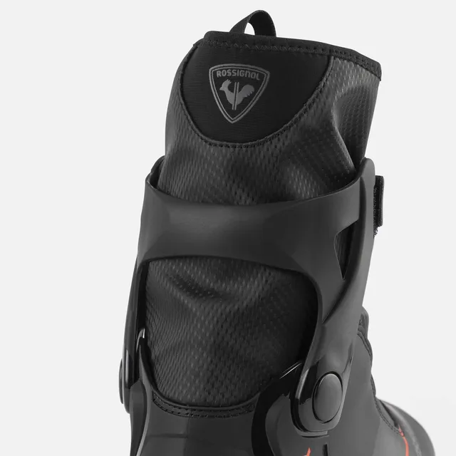 Nahaufnahme der Rückseite eines schwarzen ROSSIGNOL X-6 SKATE Skischuhs, erhältlich bei Mr. Bike Lichtenfels, mit strukturierter Manschette, Markenlogo und verstellbarem Scharnier auf weißem Hintergrund.