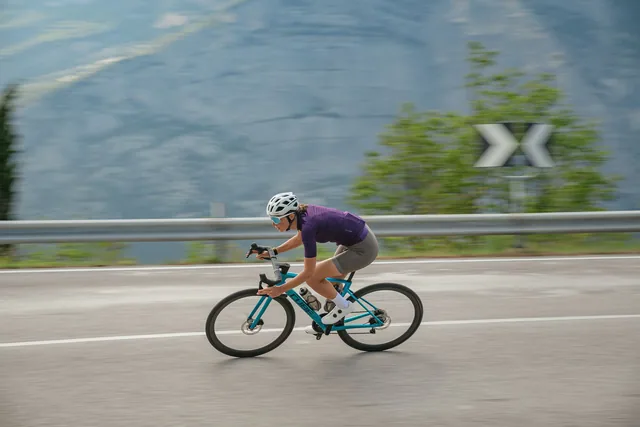 Rennradfahrerin auf CUBE Attain C:62 2027 in der Kurve