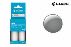 Links ist das CUBE Lackstift Set FLASH GREY glossy 2219 von Mr. Bike Lichtenfels in blauer Verpackung zu sehen, rechts ein glänzendes graues Lackmuster und rechts oben das CUBE Logo.