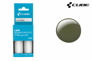 Das CUBE Lackstift Set OLIVE GREEN glossy 2223 ist in einer blauen Verpackung mit zwei Flaschen und einem glänzenden olivgrünen Swatch daneben abgebildet. Oben rechts ist das Cube-Logo zu sehen, gesehen bei Mr. Bike Lichtenfels.
